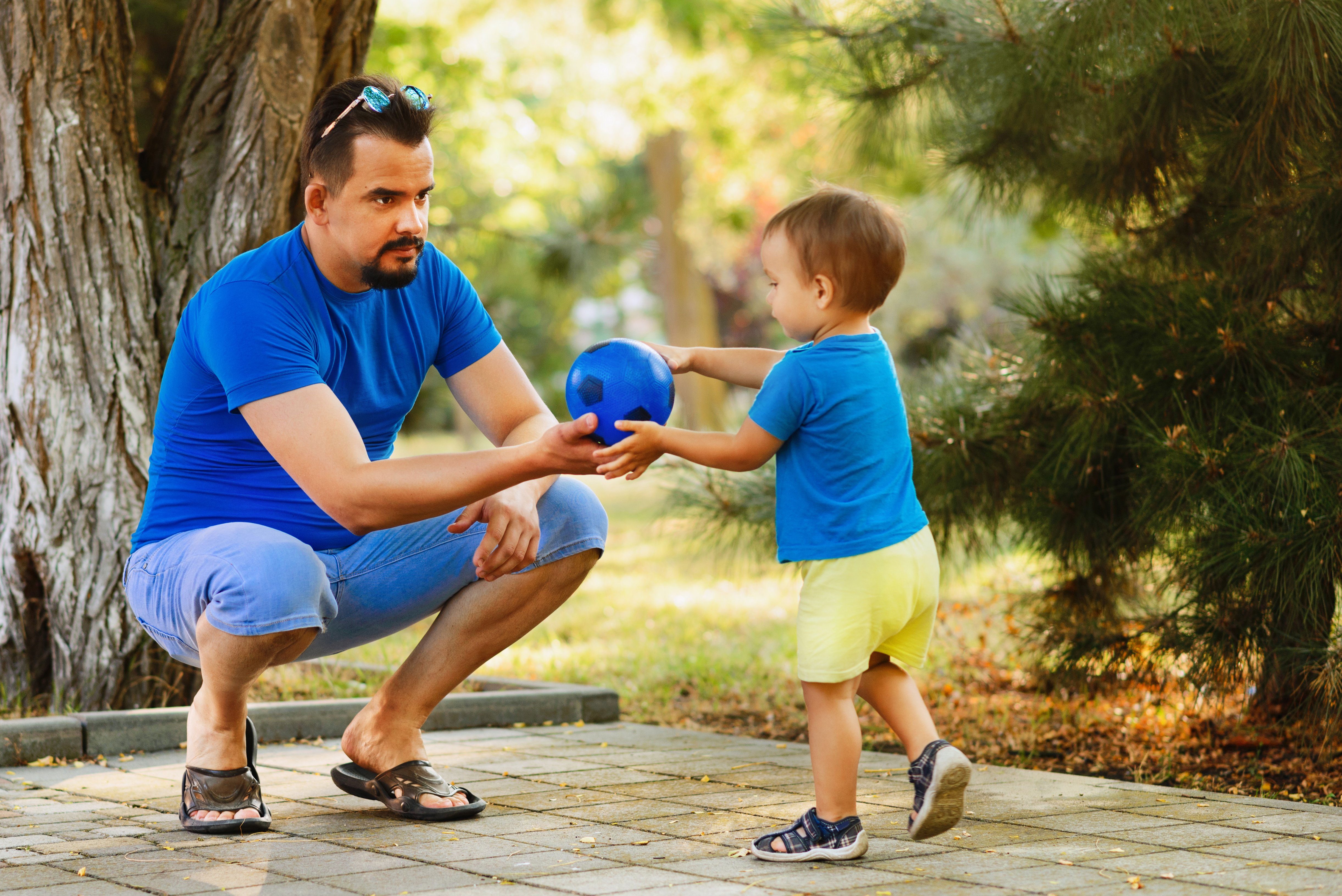 Male Toddler and adult male with ball outside